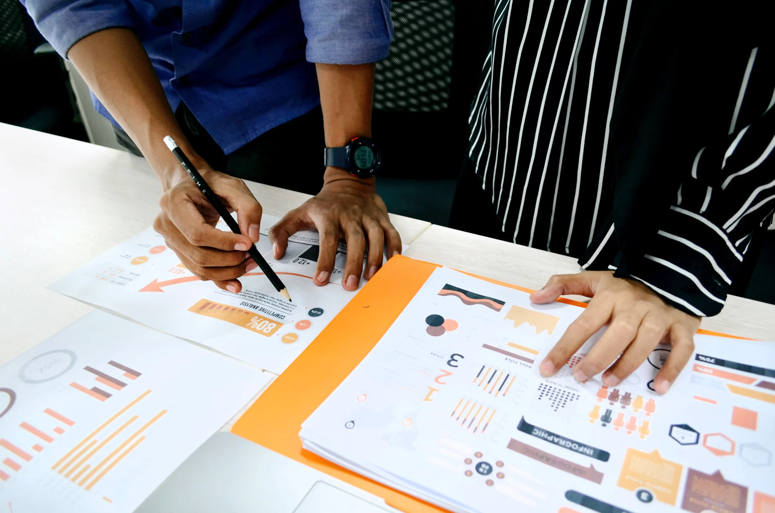 Two people reviewing graphs and financials and engaging in market research Photo courtesy of UX Indonesia